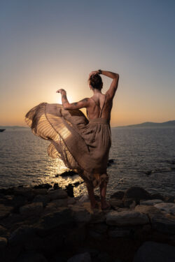 Dress in motion on the rocks of Mykonos at sunset